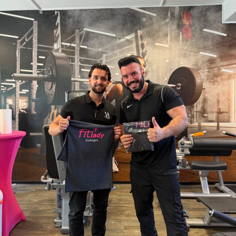 Gym Angebot Zwei Männer in Sportkleidung, lächelnd und posierend in einem Fitnessstudio.